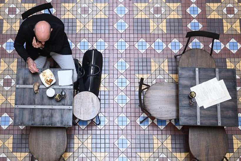 A man sits at a cafe ahead of a nationwide shut down of cafes, restaurant and licensed venues Picture: AAP
