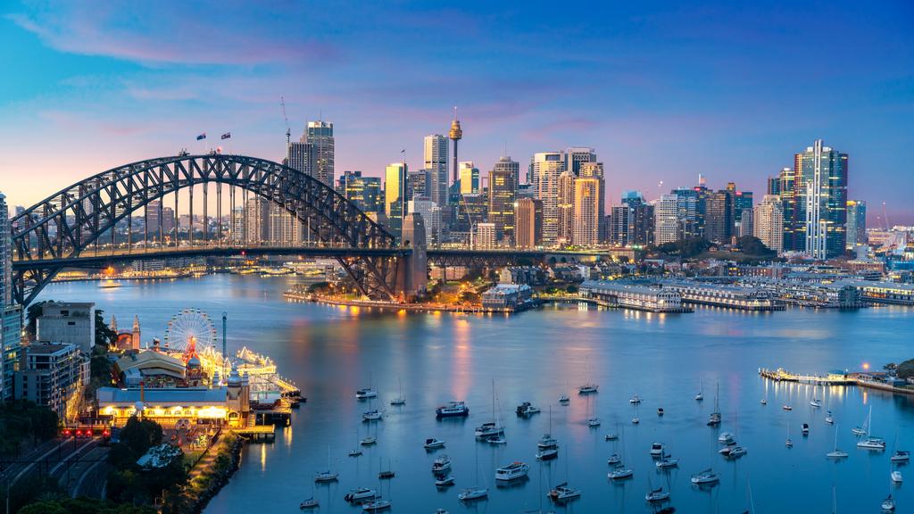 Cityscape image of Sydney, Australia with Harbor Bridge and Sydney skyline during sunset. Vacation and travel in Australia.