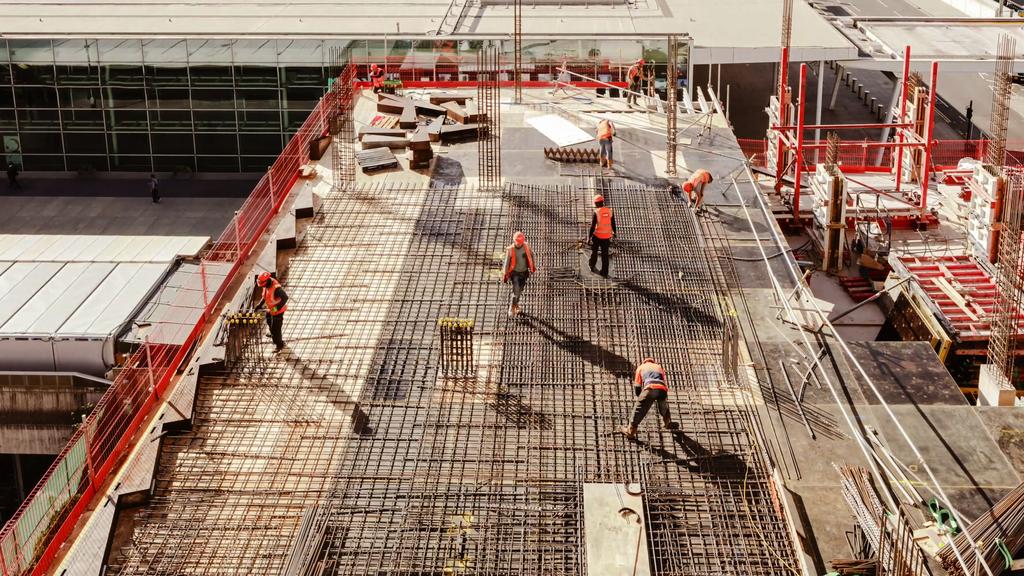 Construction workers at a construction site viewed from above, High angle view of five people with helmets.