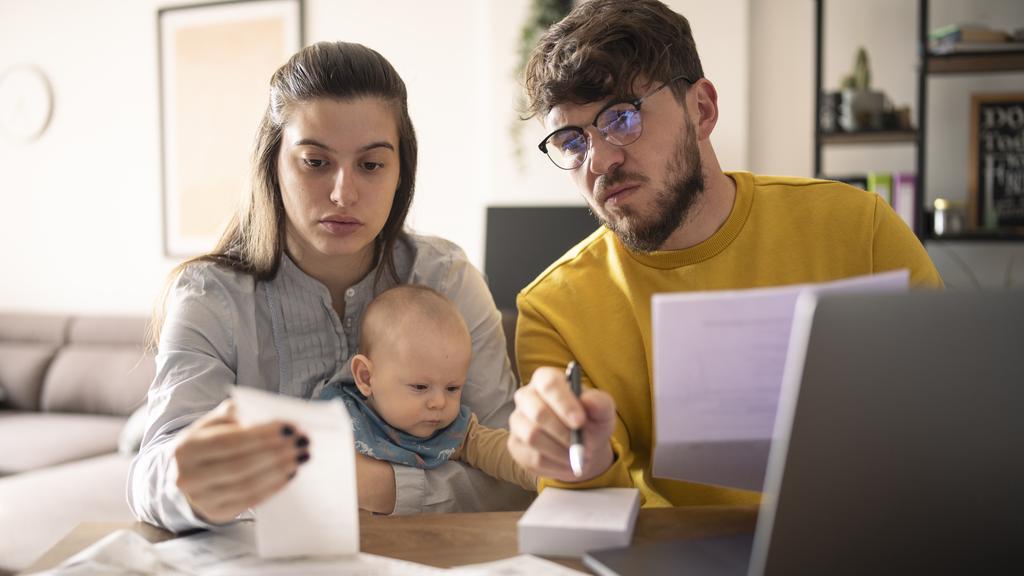 Young family with small baby calculating monthly expenses.Inflation concept.