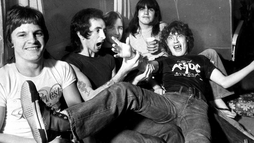 Undated. 1976? Band members AC/DC in their tour bus. (L to R) Mark Evans, Bon Scott, Phil Rudd, Malcolm Young and Angus Young. Picture: GARY GRAHAM.